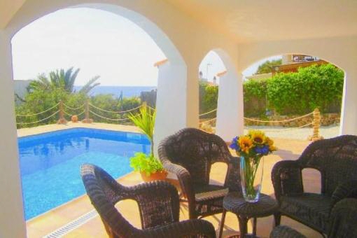 Terraza cubierta con vistas a la piscina y al mar