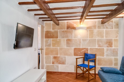 Sala de estar acogedora con pared de piedra